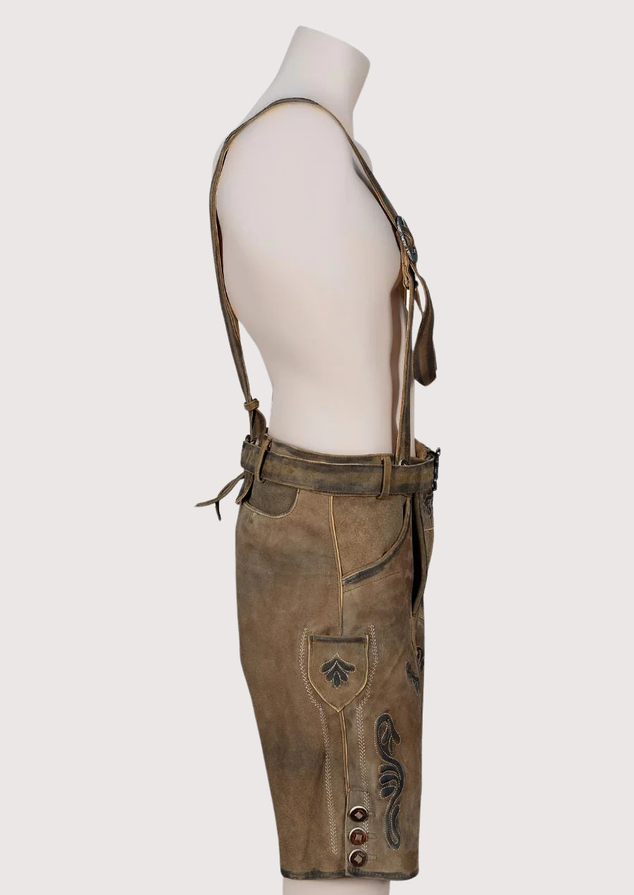 Authentic Oktoberfest lederhosen outfit with leather shorts, suspenders, and embroidered detailing in vintage brown finish.