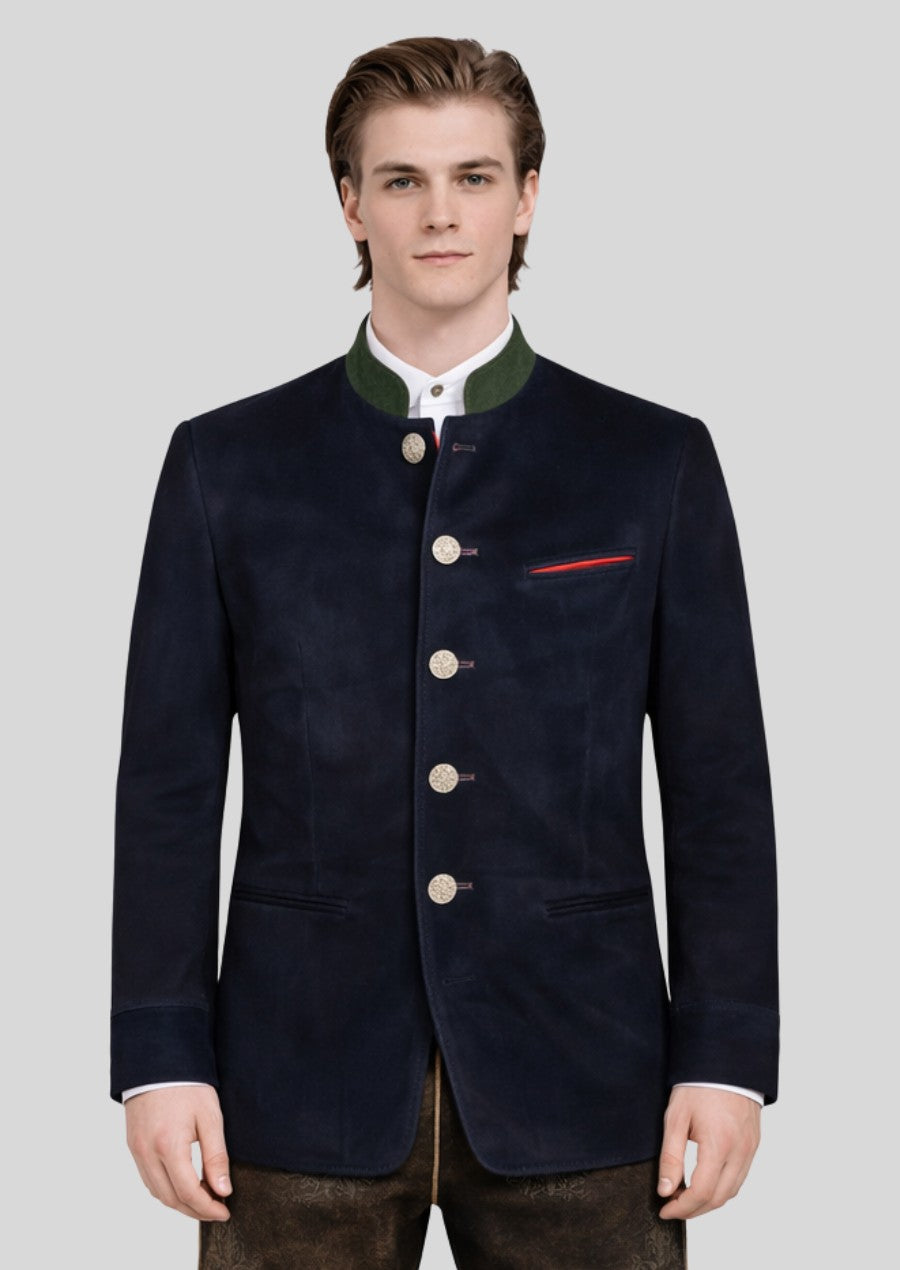 Male model wearing a navy blue Bavarian trachten jacket with green collar trim and traditional silver buttons.